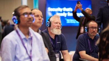 Cybersecurity professionals watch an Infosecurity Europe seminar listening via headsets 