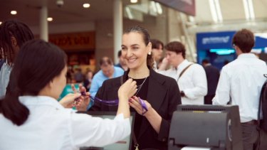 Information security professionals speak to staff assisting them at registration desk for Infosecurity Europe 