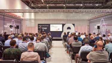 Infosecurity Europe attendees watch a speaker present a Strategy Talk conference session