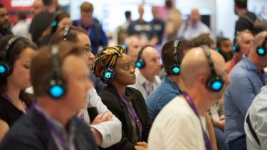 Infosecurity Europe visitors watch a Technology Showcase session and listen via headsets