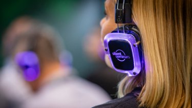 A lady wearing a headphone listening to seminar