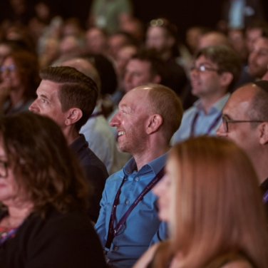 Infosecurity Europe attendees smiling during a conference session